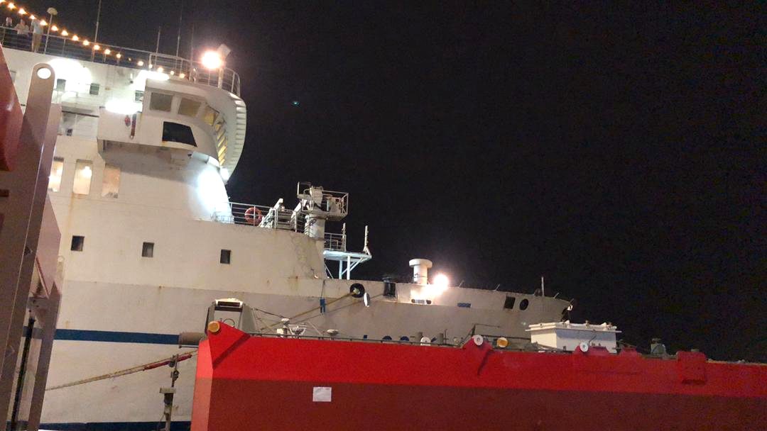 Cargo vessel alongside at night during ship agency and stevedoring operations